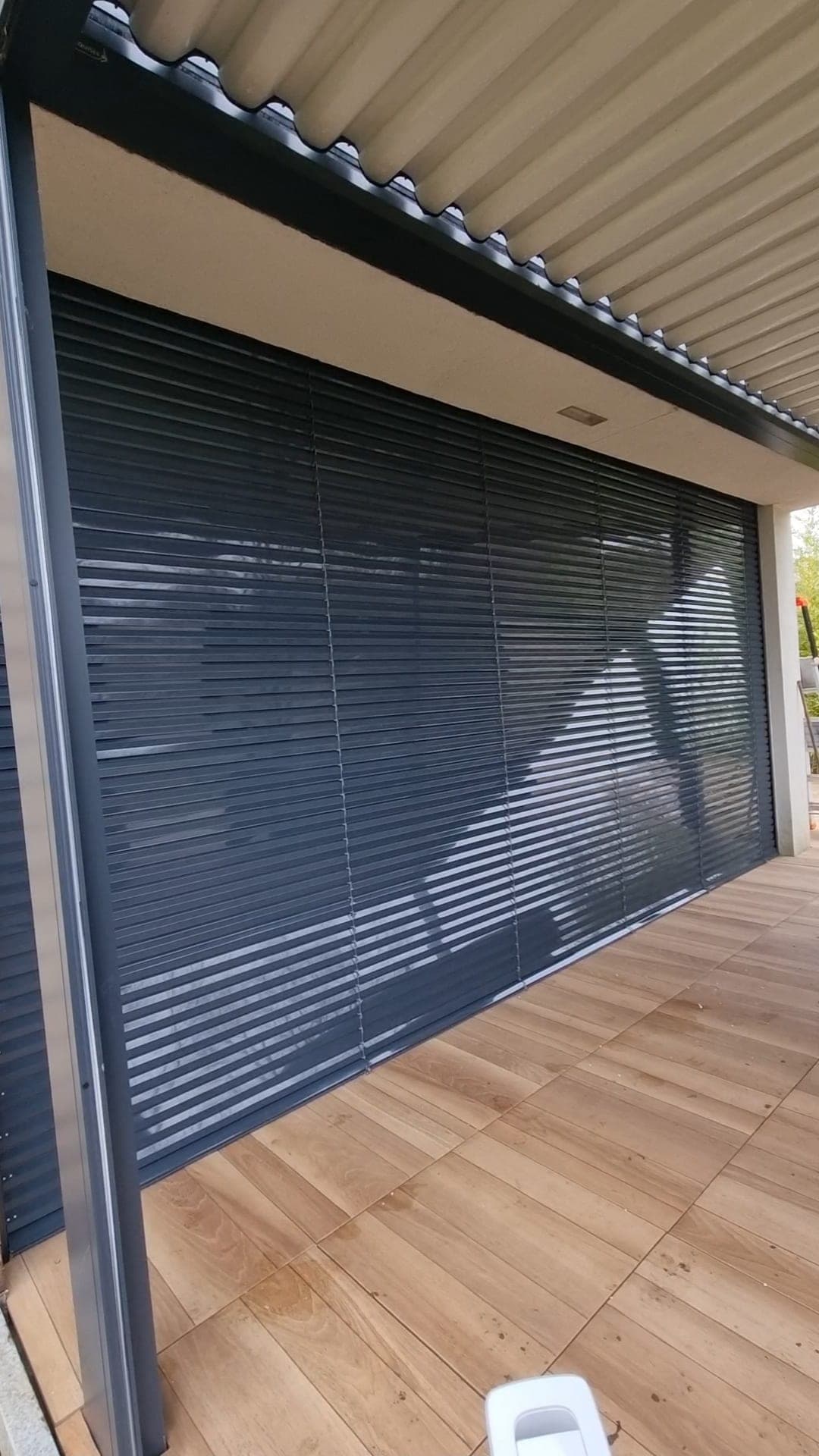 Vue large d’un brise-soleil orientable anthracite protégeant une grande baie vitrée