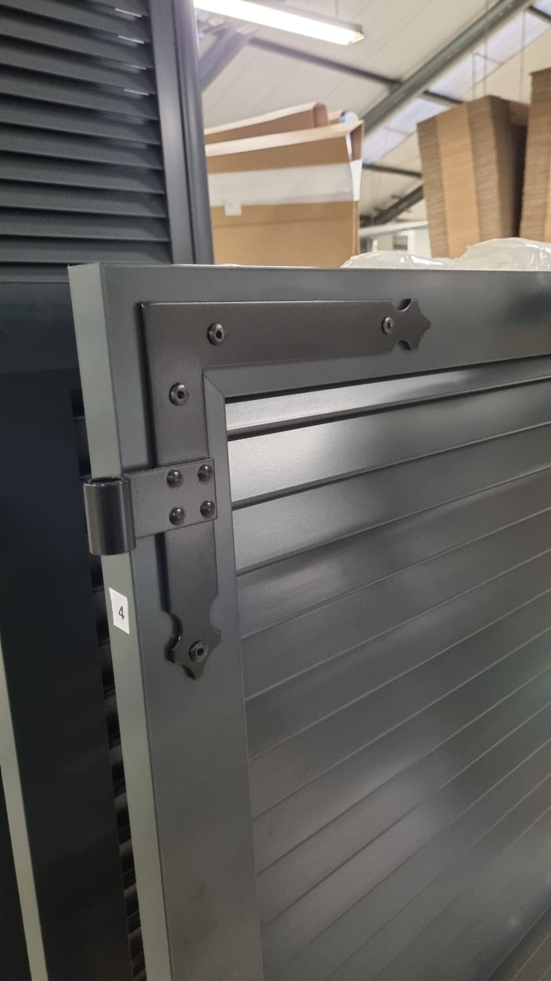 Détail d’une penture et d’un ferrage sur un volet battant aluminium anthracite